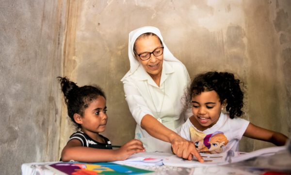 Schwester Inês (Congregação das Irmãs Franciscanas de Nossa Senhora do Amparo) besucht die beiden Mädchen Manuella (6) und Gabriella (5). Die alleinerziehende Mutter ist in der Arbeit, so dass die Mädchen weitgehend unbeaufsichtigt zu Hause sind, Stadtteil Bairro Roselândia, Barra Mansa, Bundesland Rio de Janeiro, Brasilien