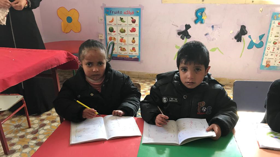 Kinder aus Gaza schreiben in Schulhefte