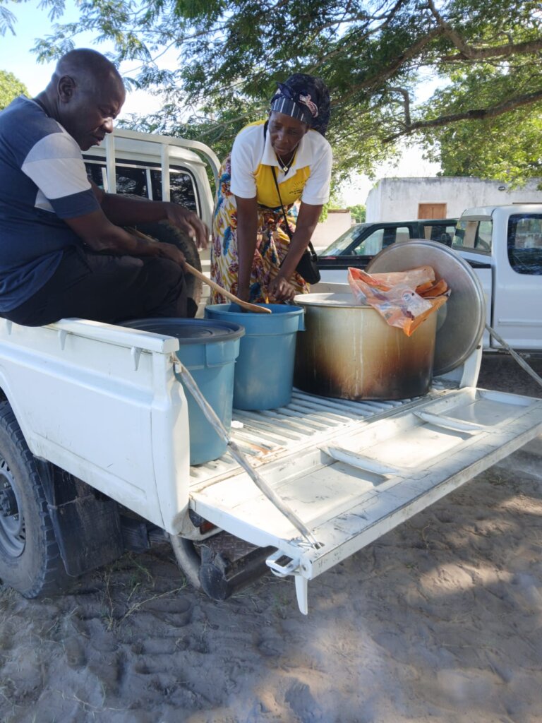 Ein Mann und eine Frau stehen auf der Ladefläche eines Pickups, der mit Eimern voller Nahrung beladen ist.