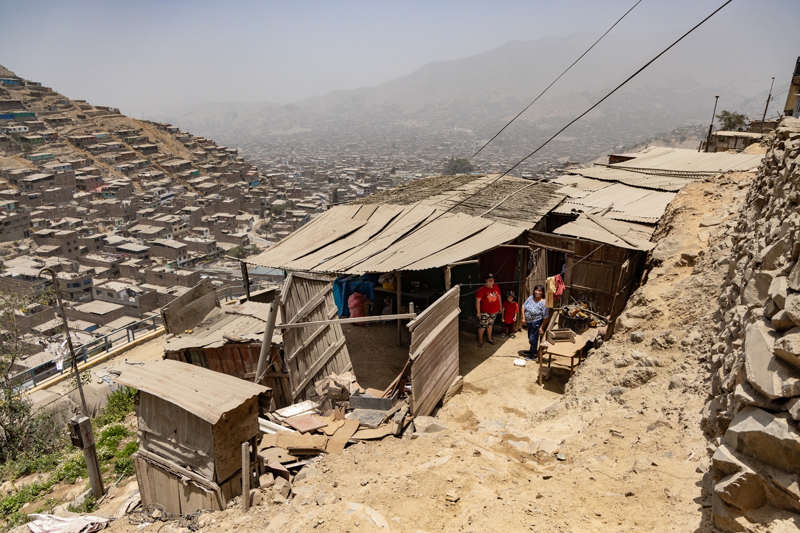 Familien leben in einfachen Hütten an den trockenen Berghängen von Huaycán in Peru.