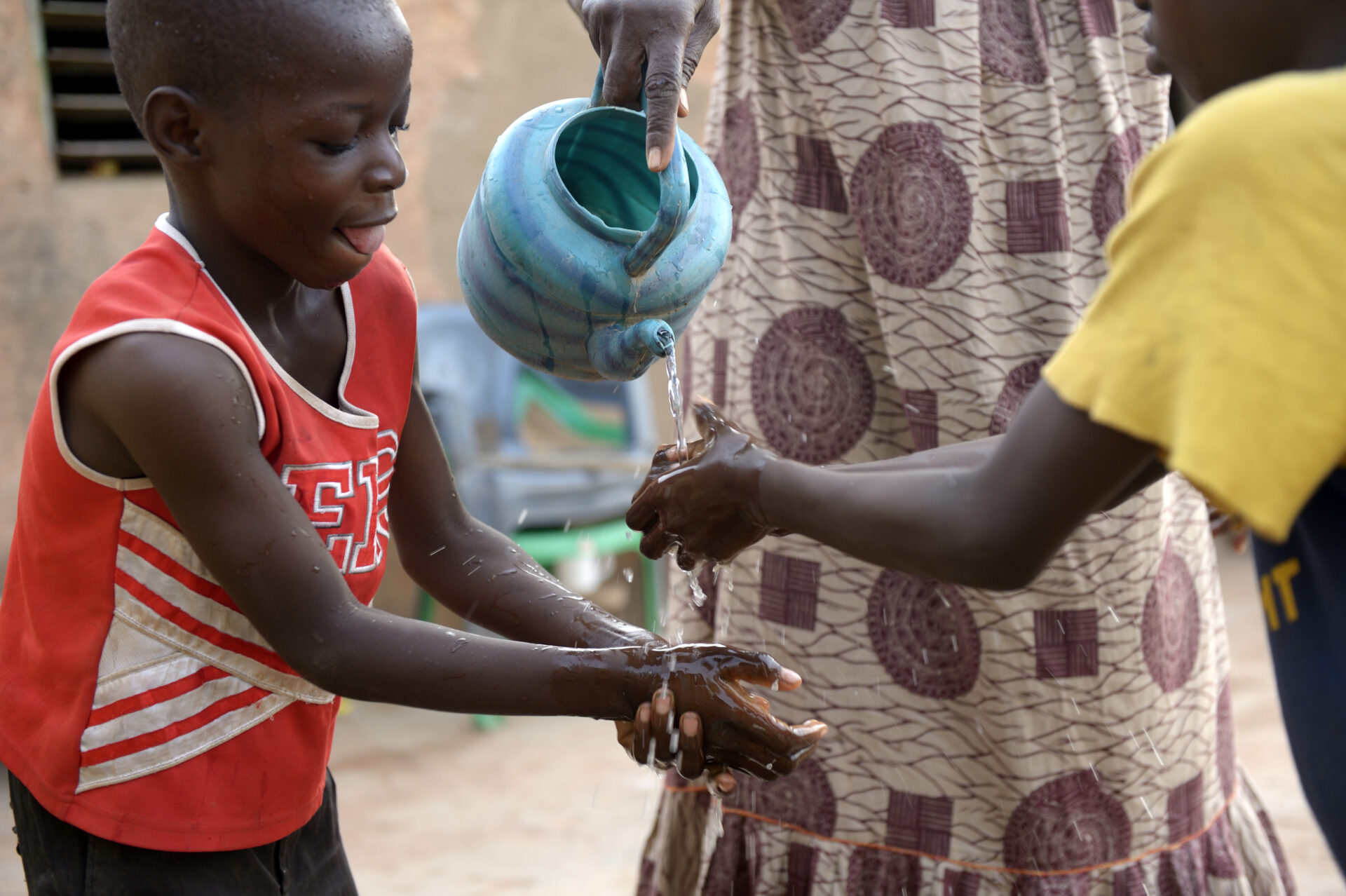Ein Kind wäscht sich die Hände. Hygiene und sauberes Wasser schützen Familien vor Ebola im Kongo.