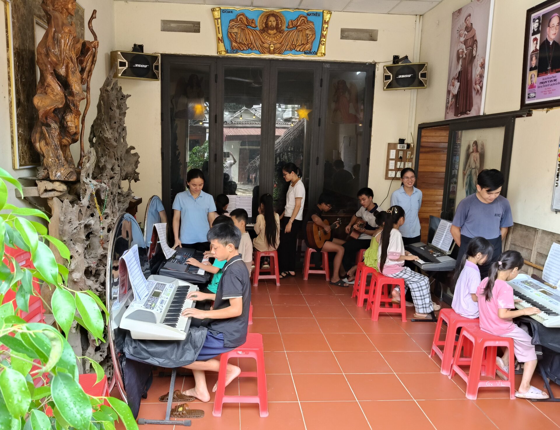 Kinder und Jugendliche nehmen während eines Sommerprogramms der Franziskaner in Lang Son, Vietnam, an gemeinsamem Musikunterricht mit Keyboards und Gitarren teil.