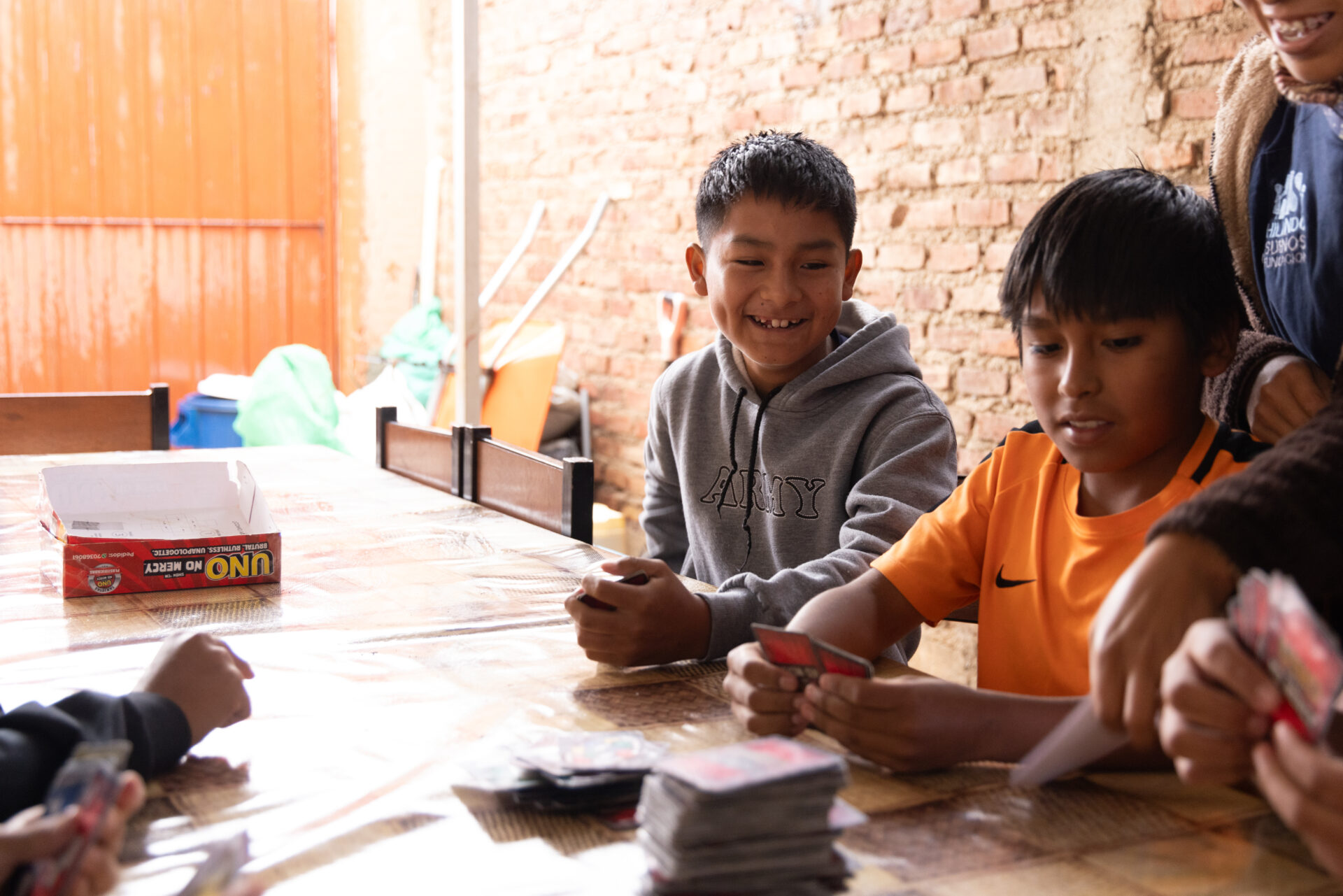 Kinder und Jugendliche spielen gemeinsam Karten im Rahmen eines Freiwilligendienst-Projekts in Bolivien.
