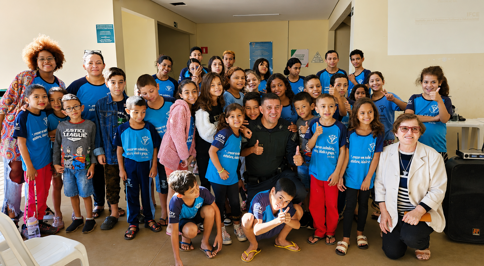 Eine große Gruppe von Kindern und Jugendlichen, überwiegend in blauen T-Shirts, posiert gemeinsam mit mehreren Erwachsenen für ein Gruppenfoto.