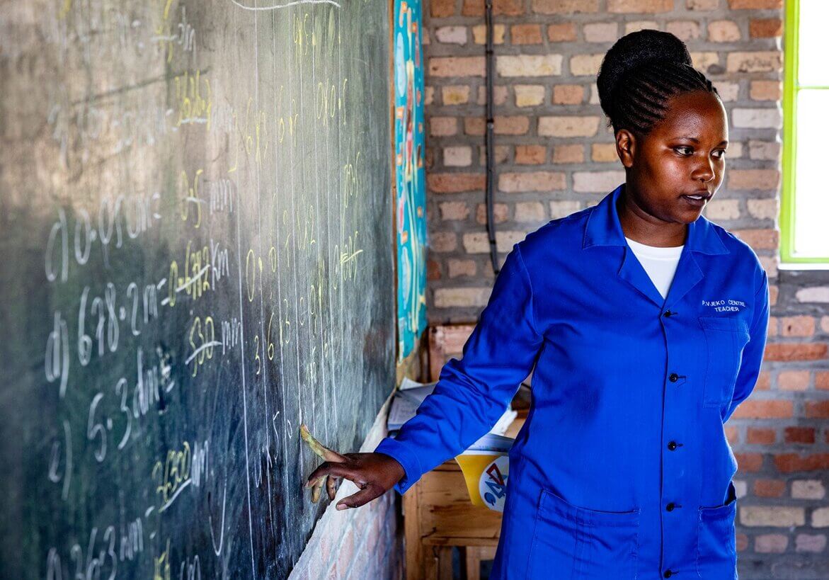 Junge Lehrerin unterrichtet in einem Klassenraum in Ruanda. Bildung schafft Perspektiven und stärkt die Rolle von Frauen in der Gesellschaft.