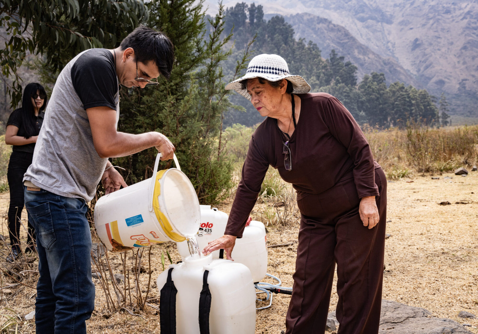 Cochabamba, Bolivien  Freiwillige Helfer füllen Wasser zur Bewässerung der Setzlinge in Sprühgräte.